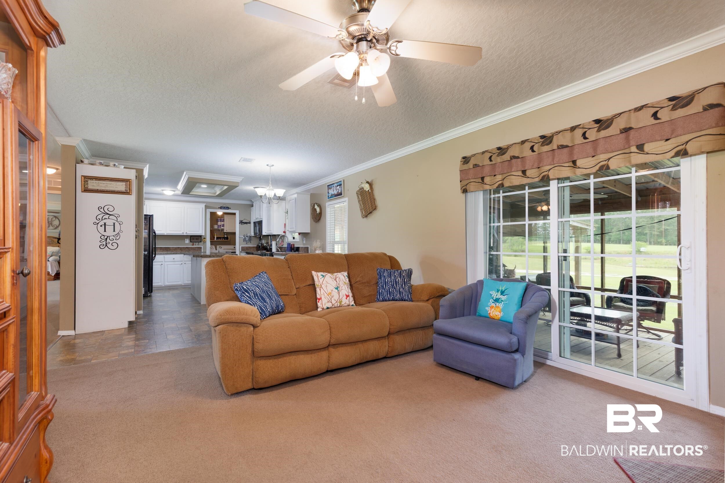 6725 Upper Creek Road Flomaton, AL 36441 - Photo 37 of 61 Living area with a textured ceiling, dark colored carpet, crown molding, and a ceiling fan