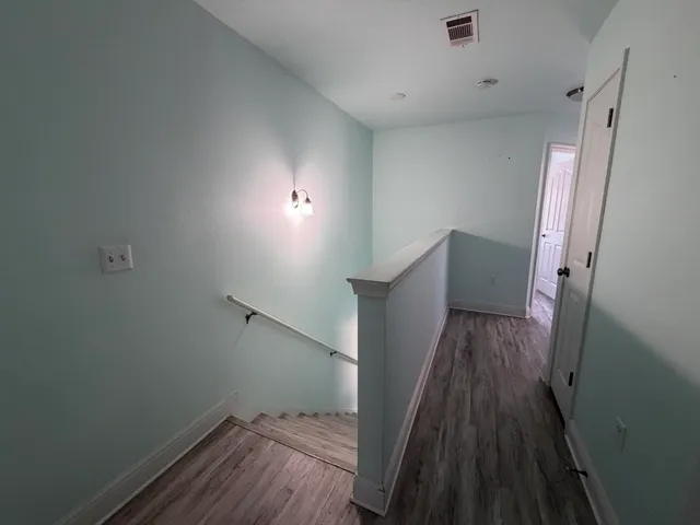 a view of a hallway with wooden floor