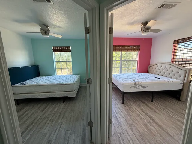 a bedroom with a bed wooden floor and window