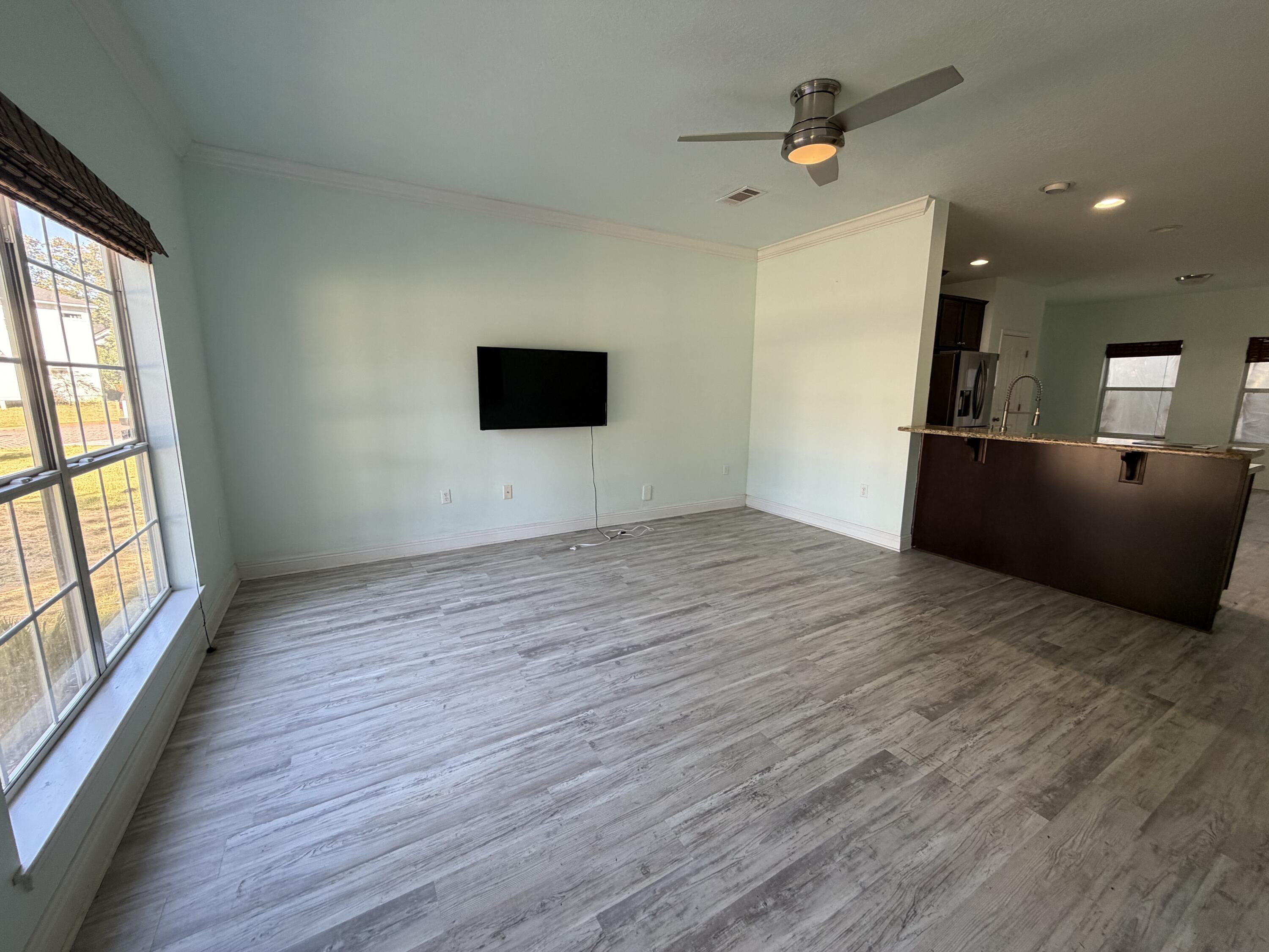 114 Rearden Way Santa Rosa Beach, FL 32459 - Photo 5 of 25 an empty room with wooden floor and windows