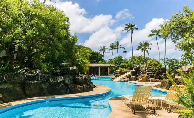 a view of a backyard with couches plants and lake view
