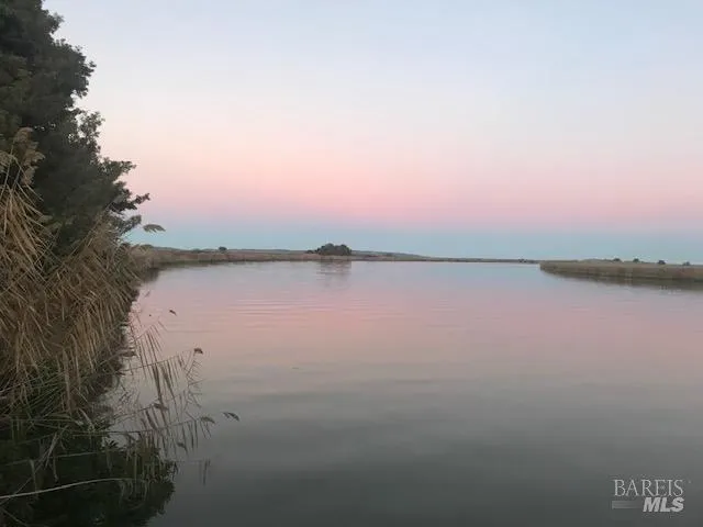 a view of lake with sunset in background