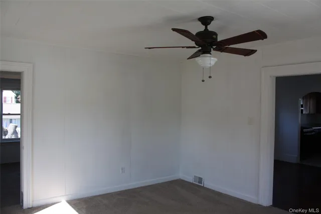 a view of a room with a ceiling fan and a window