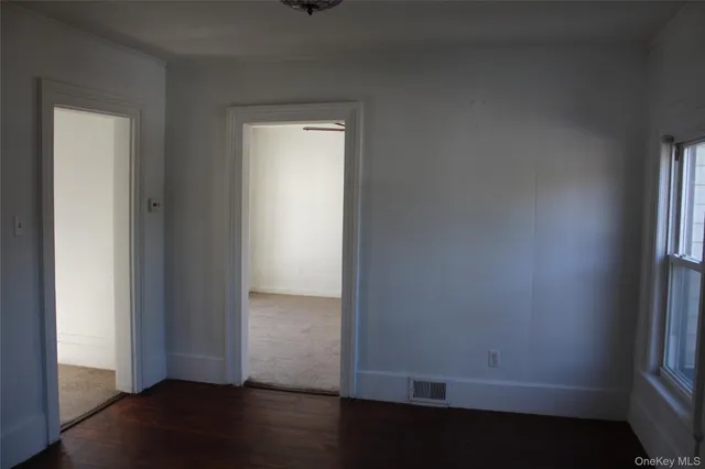 an empty room with wooden floor and closet