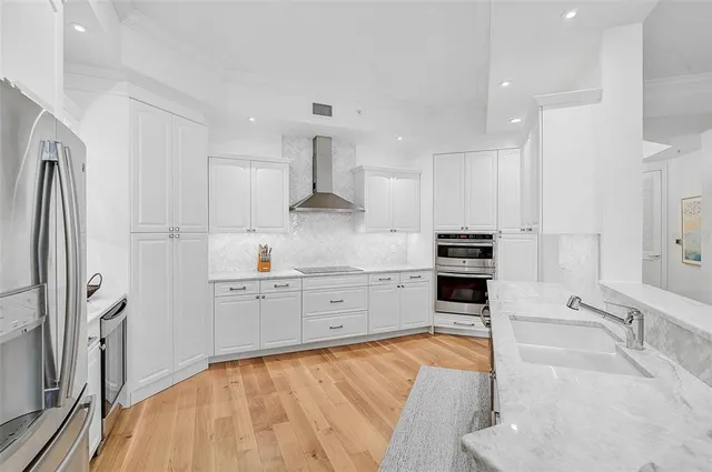 a large kitchen with stainless steel appliances cabinets a sink and a stove