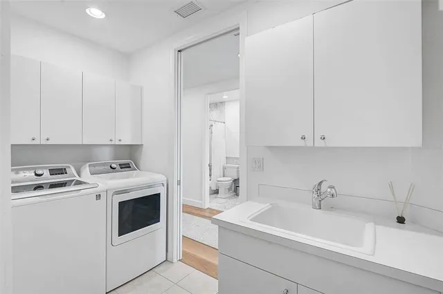 a view of a sink and dishwasher with white cabinets