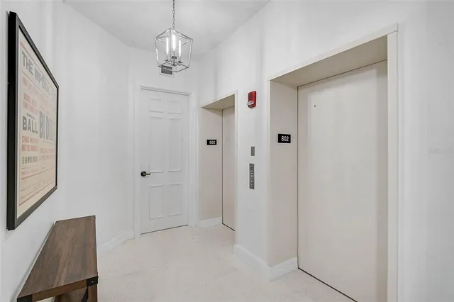 a view of a hallway with chandelier and entryway