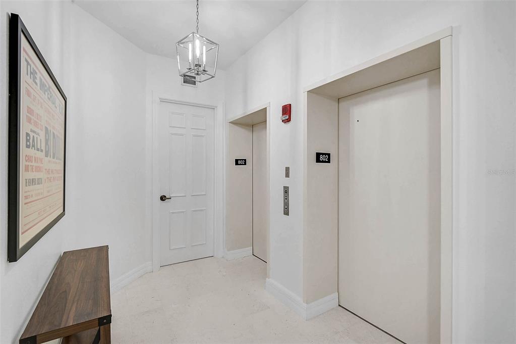 409 North Point Road, Unit 802 Osprey, FL 34229 - Photo 7 of 38 a view of a hallway with chandelier and entryway