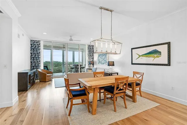 a view of a dining room with furniture a chandelier and wooden floor