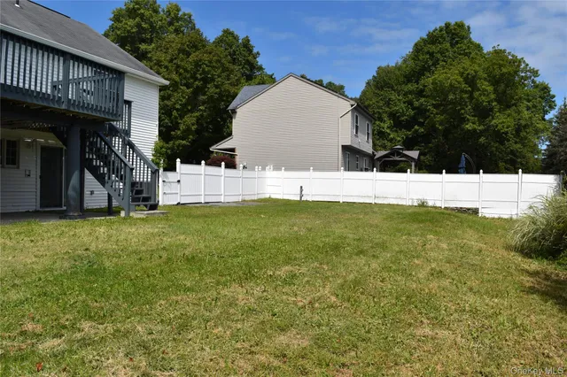 a view of backyard with large trees and plants