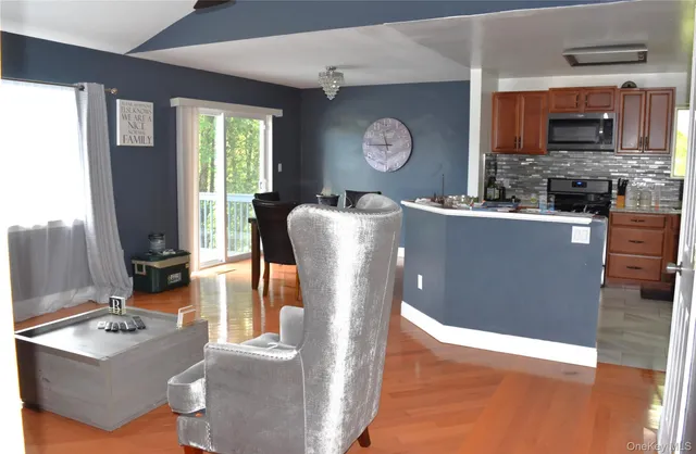 a living room with stainless steel appliances kitchen island granite countertop furniture a rug and a window