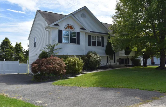 a front view of a house with a garden and trees