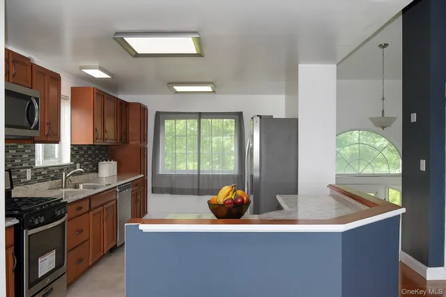 a kitchen with stainless steel appliances granite countertop a sink a stove and a refrigerator