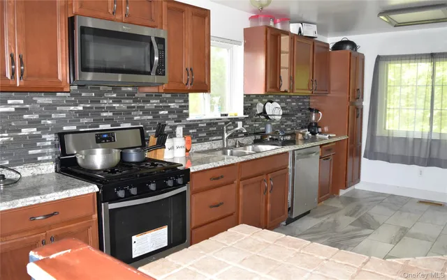 a kitchen with stainless steel appliances a stove sink and microwave