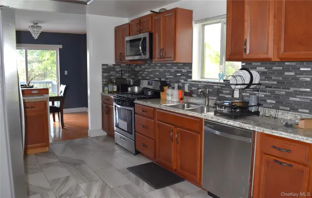 a kitchen with stainless steel appliances granite countertop a stove a sink and a microwave