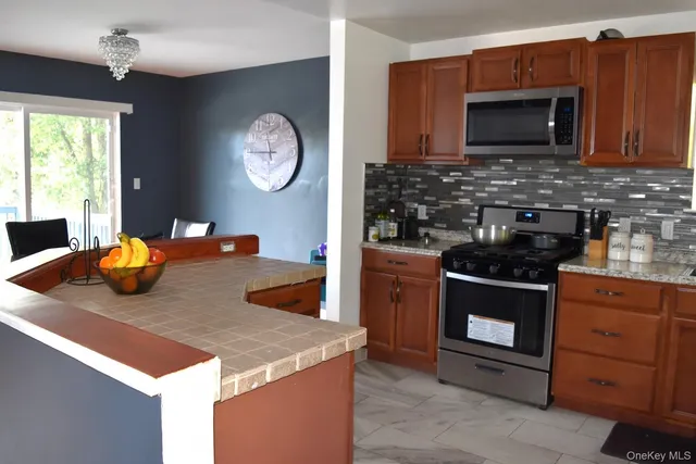 a kitchen with stainless steel appliances granite countertop a stove a sink and a microwave