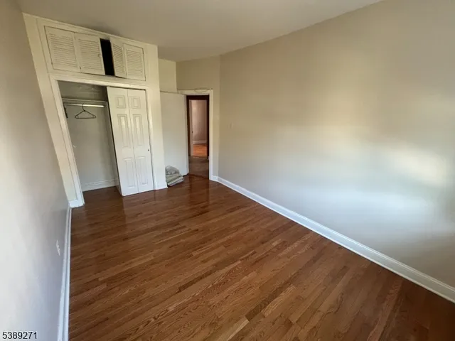 an empty room with wooden floor and entrance