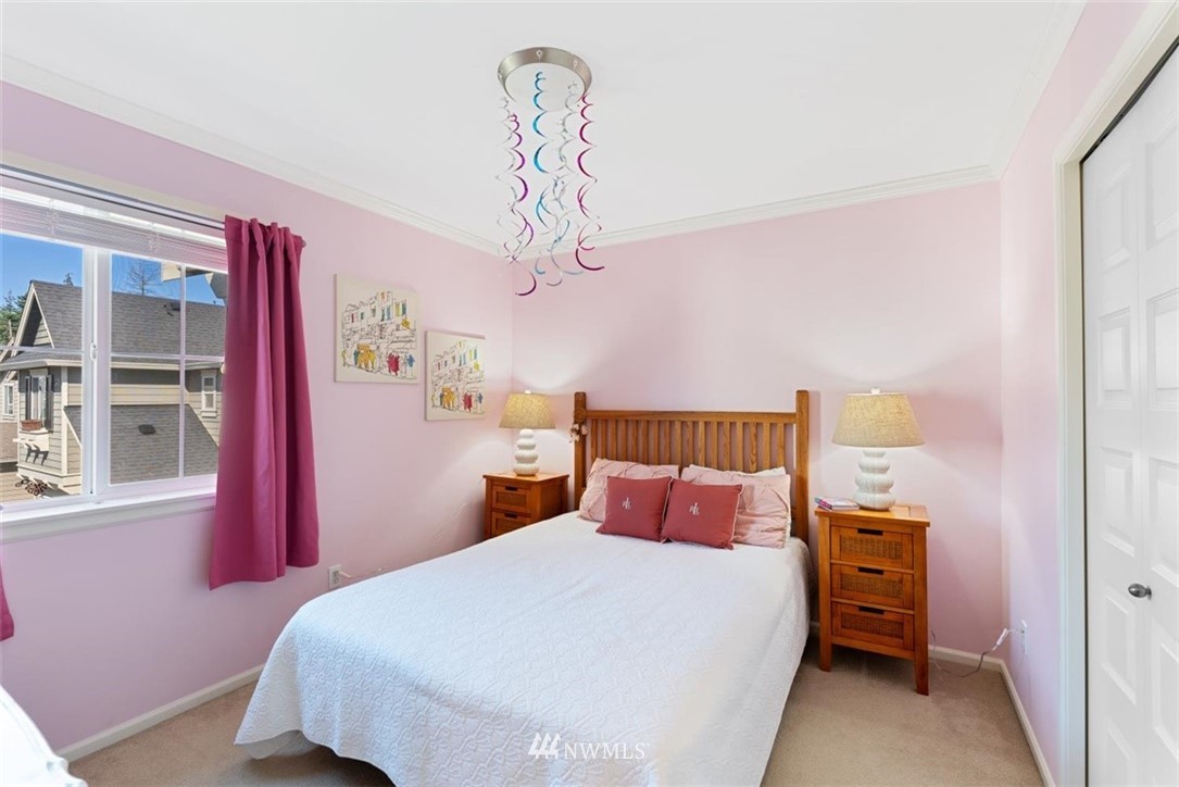 3615 182nd Street Southeast, Unit 74 Bothell, WA 98012 - Photo 22 of 33 a bedroom with a bed and a chandelier