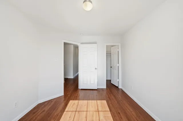 a view of a room with wooden floor and white walls