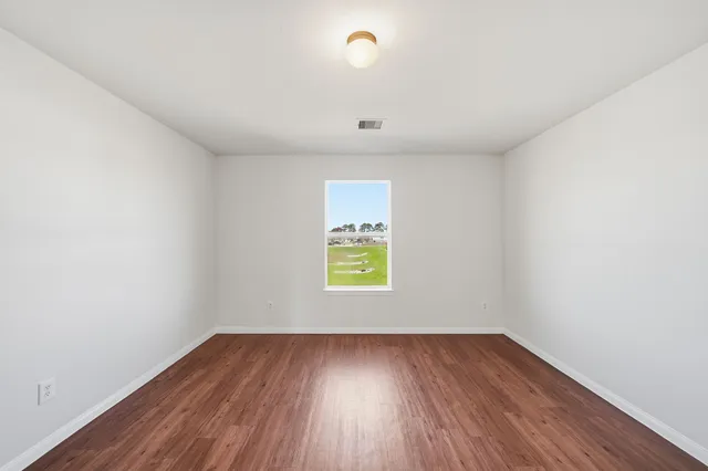 a view of room with window and wooden floor