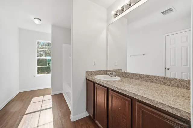 a view of kitchen island a sink wooden floor and entryway