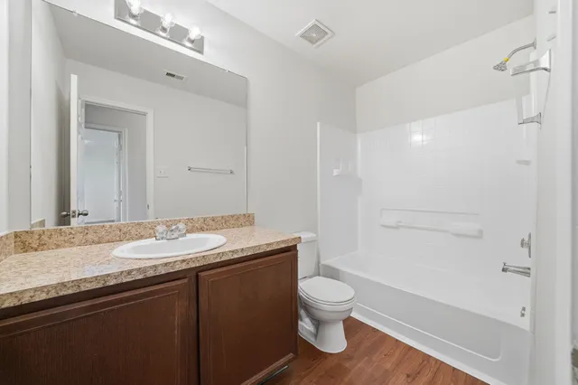 a bathroom with a granite countertop sink a toilet and shower