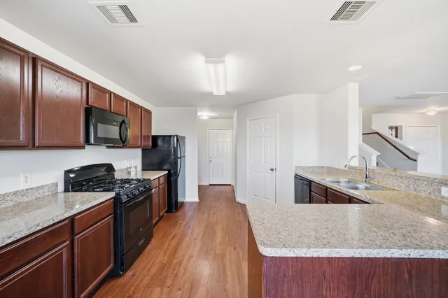 a kitchen with stainless steel appliances granite countertop a sink stove and refrigerator