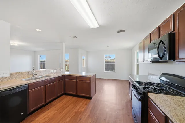a kitchen with stainless steel appliances granite countertop a stove and a sink