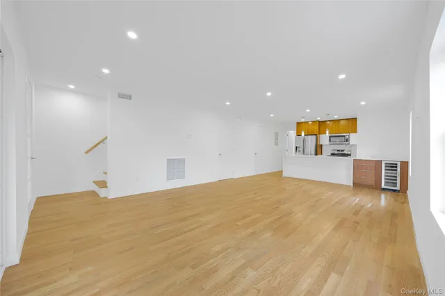 a view of a big room with wooden floor and windows