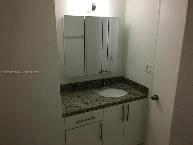 a bathroom with a granite countertop sink and vanity