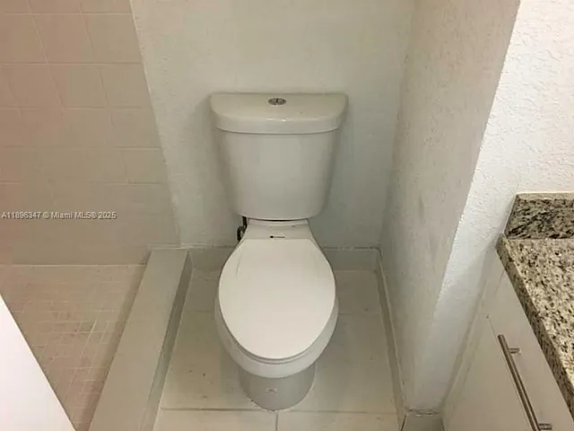 a white toilet sitting next to a shower