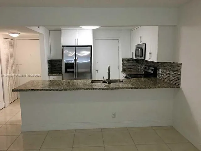 a kitchen with stainless steel appliances granite countertop a sink and a granite counter tops
