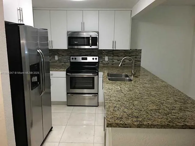 a kitchen with a refrigerator stove and microwave