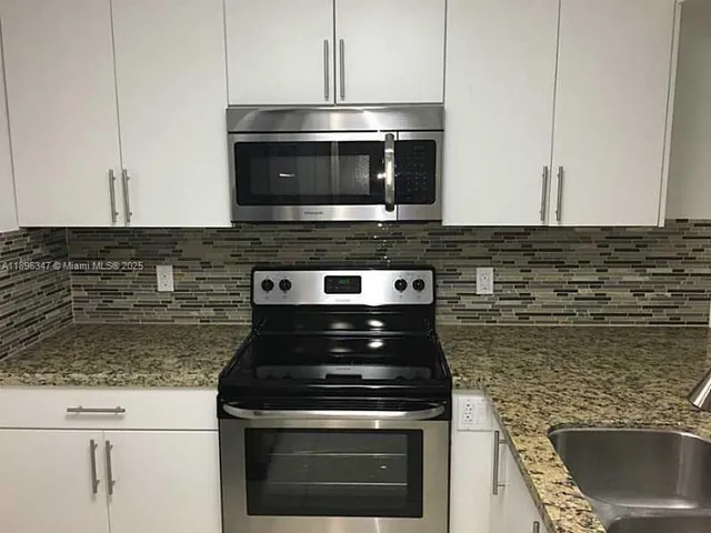 a stove top oven sitting inside of a kitchen