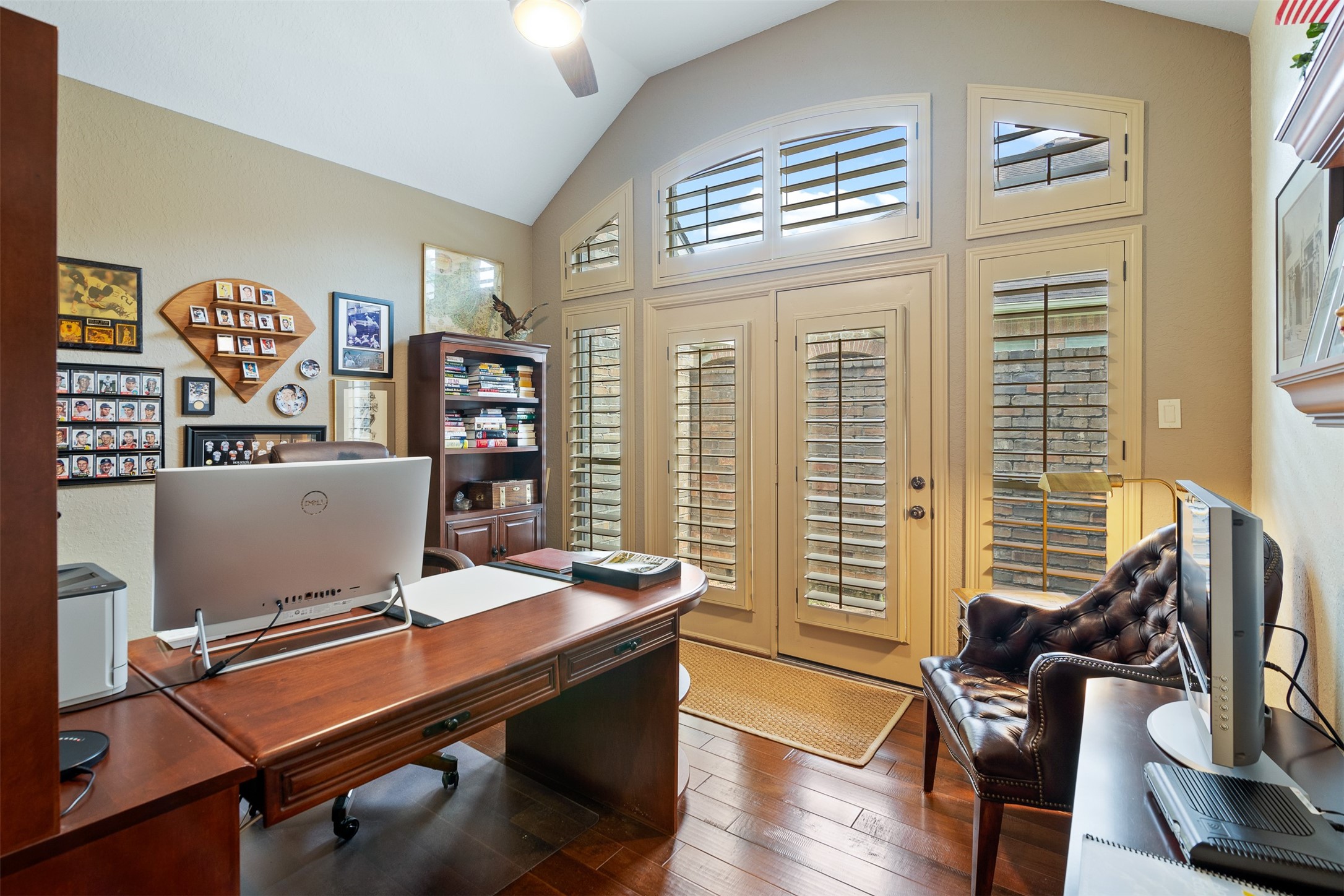 19507 Remington Manor Street Spring, TX 77379 - Photo 4 of 33 The study is spacious and features wood floors, ceiling fan and a wall of windows with double doors leading outside complimented by wood shutters.