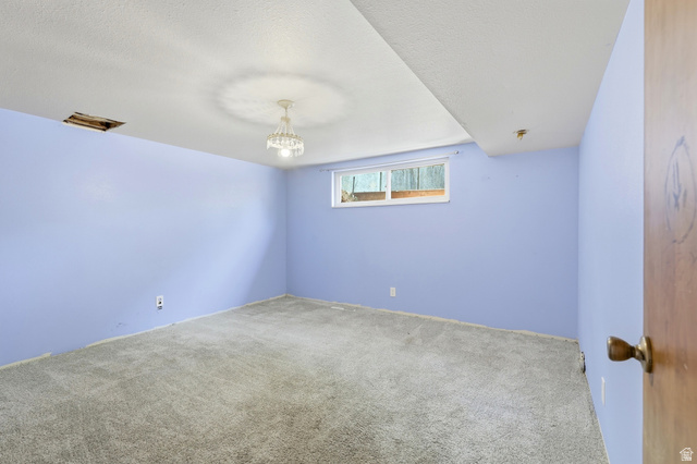 1410 Sumac Drive Logan, UT 84321 - Photo 19 of 28 Spacious room featuring light blue walls, gray carpet, and a window with exterior visibility