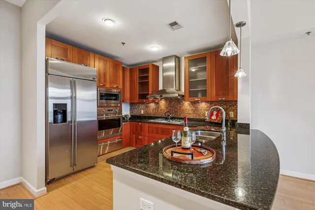 a kitchen with stainless steel appliances granite countertop a sink and a refrigerator