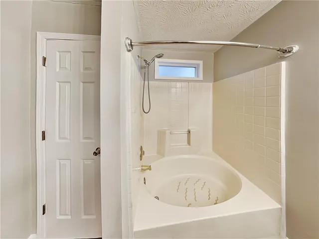a white bath tub sitting next to a shower