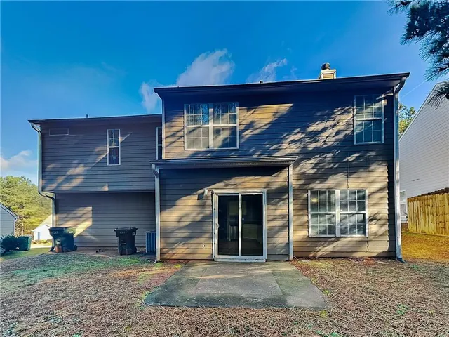 a view of a house with a patio and a yard