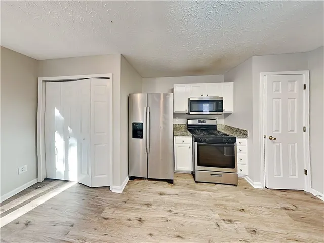 a view of kitchen with refrigerator stove and microwave