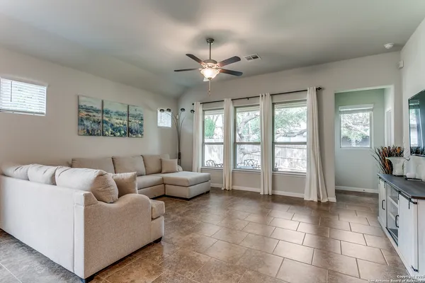 a living room with furniture and a ceiling fan