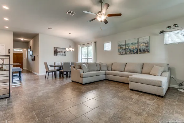 a living room with furniture and a view of kitchen