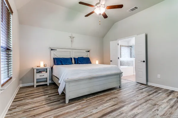 a bedroom with a large bed and a chandelier