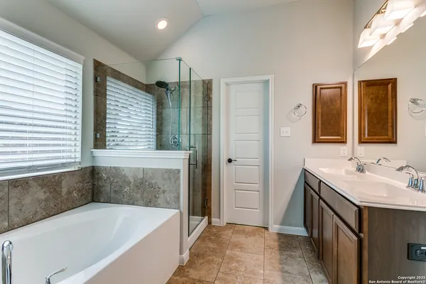a bathroom with a tub sink and mirror