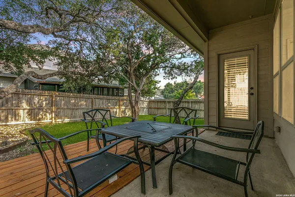 a view of a patio with table and chairs with wooden floor and fence