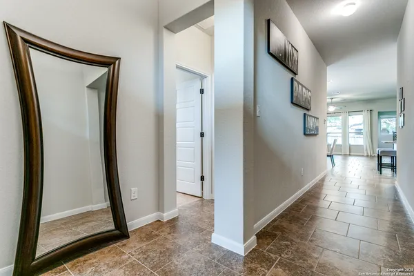 a view of a hallway with windows and living room