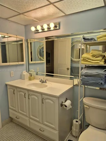 a bathroom with a granite countertop toilet sink and mirror