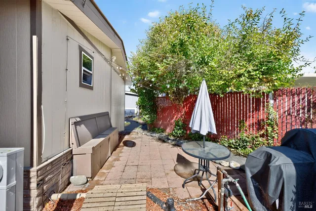 a view of backyard with table and chairs and potted plants