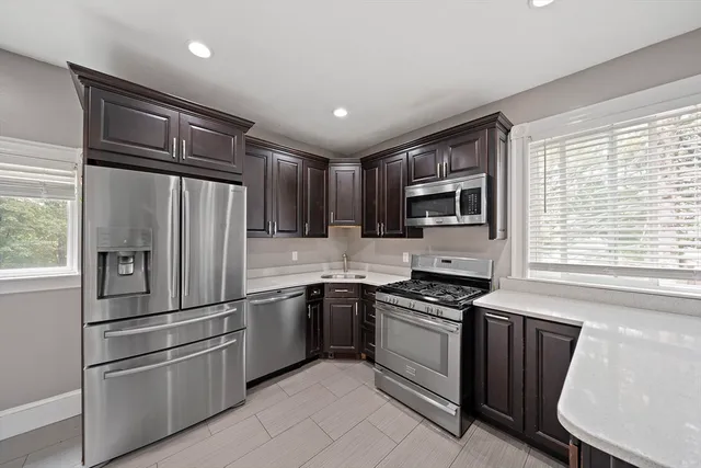 a kitchen with granite countertop stainless steel appliances a refrigerator sink and microwave
