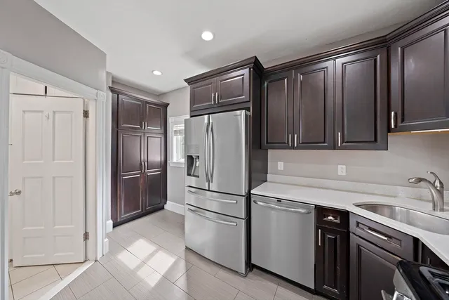 a kitchen with stainless steel appliances granite countertop a refrigerator and a sink